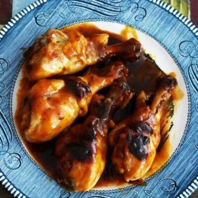 A plate of glazed Instant Pot BBQ Chicken drumsticks coated in a rich, dark sauce.