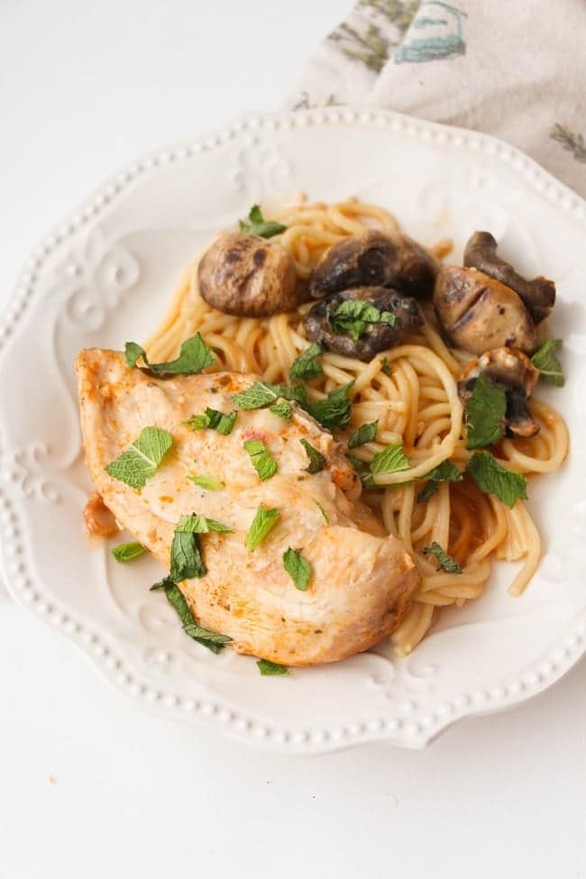 chicken, noodles and mushrooms on a white plate