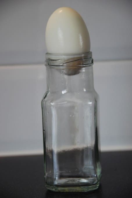 a glass jar with an egg at the top