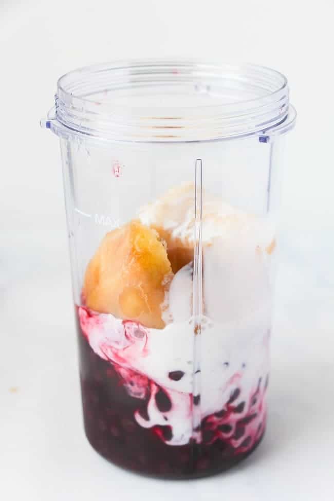blueberries, Greek yogurt and banana in a blender jar with a white background