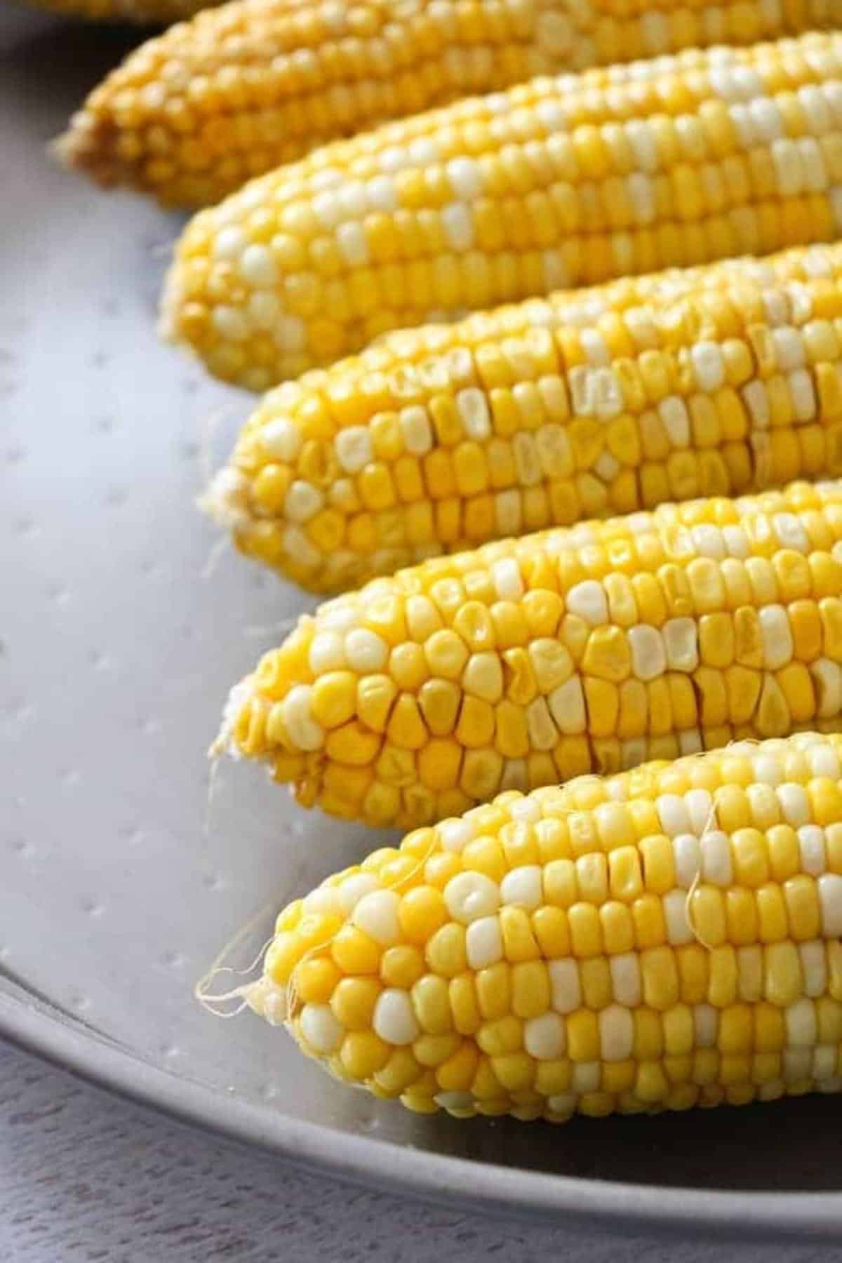 Corn on the cob on a metal dish.