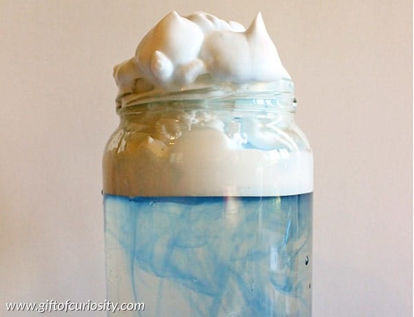 a jar with liquid in it and shaving cream at the top to make it look like a rain cloud in a jar