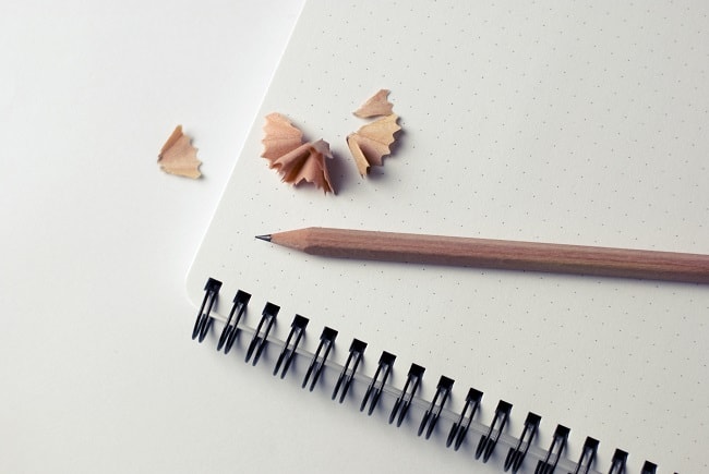 a notebook with a pencil and pencil shavings on it