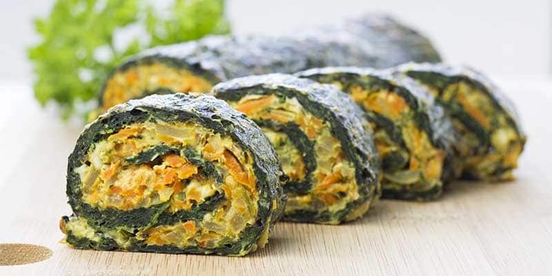 sliced spinach roll on a brown table