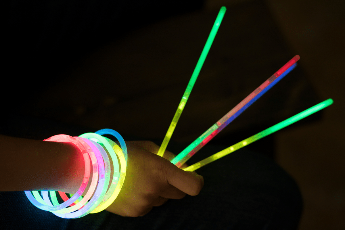 a kid holding glow sticks.