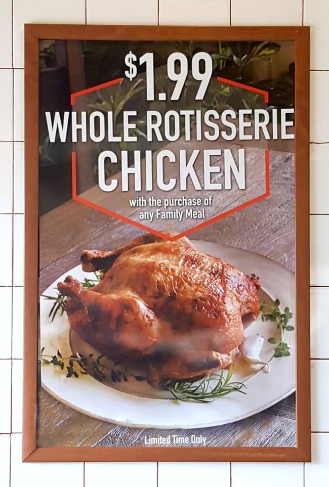a sign on a wall in a Boston Market store advertising $1.99 Whole Rotisserie Chicken