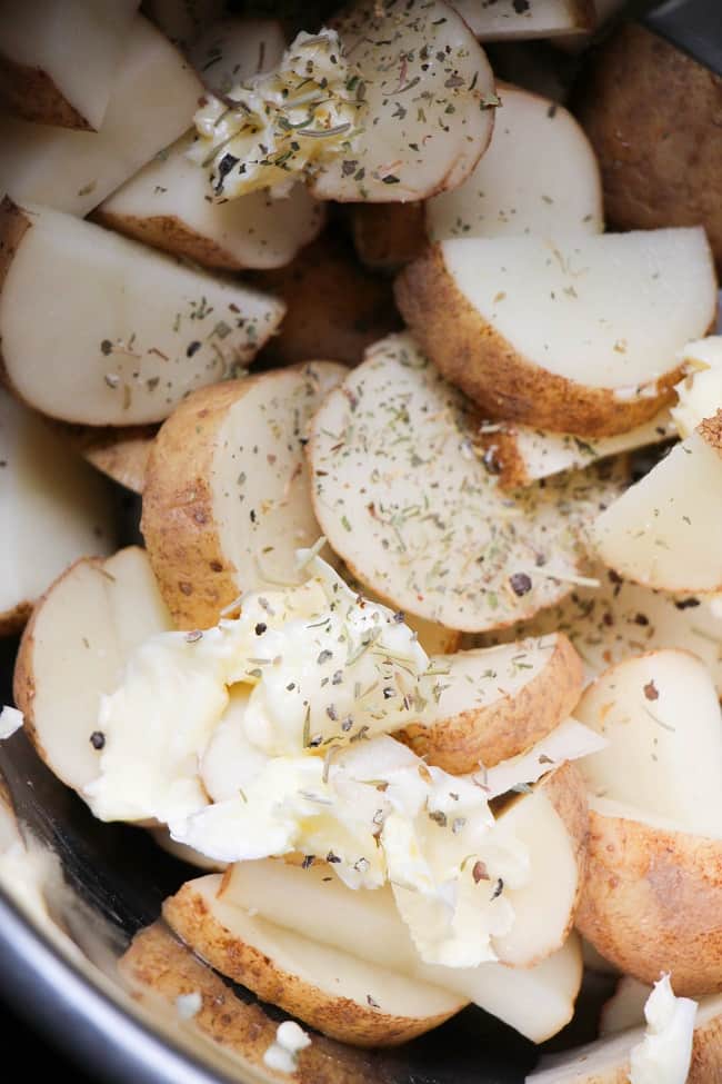 sliced potatoes and seasonings, topped with butter, in an instant pot