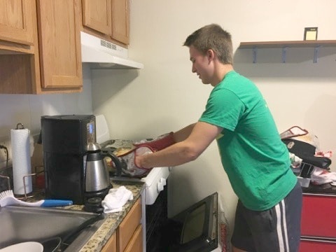 a young man college student cooking in a kitchen