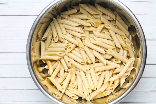 cooked pasta in an instant pot on a white wood background