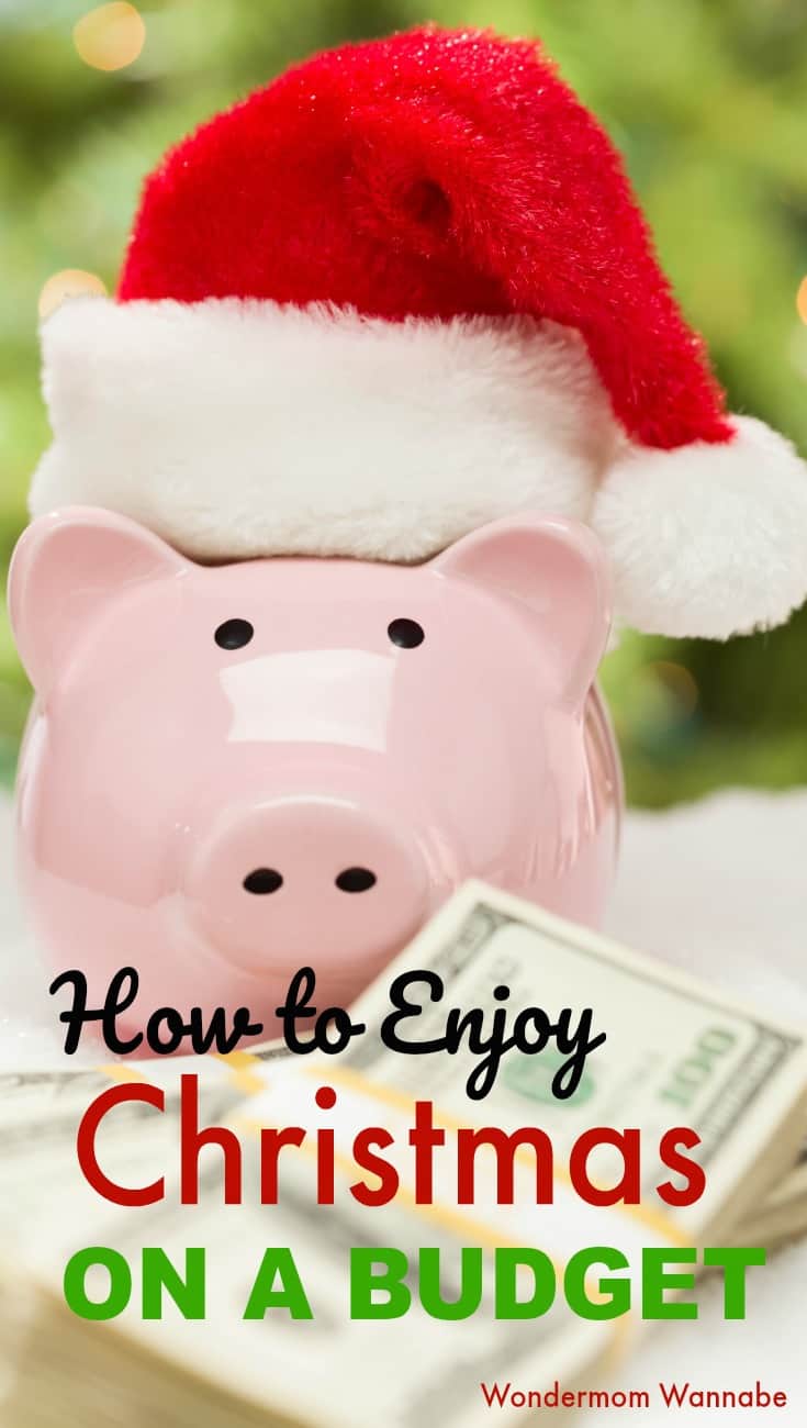 a pink piggy bank with a Santa hat on it with a stack of hundred dollar bills in front of it with a green background and title text reading How to Enjoy Christmas on a Budget
