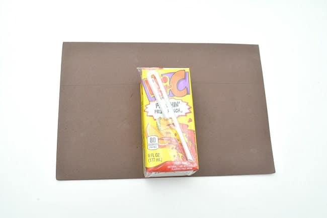 a juice box on brown craft foam on a white background