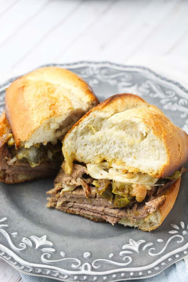 philly cheesesteak sandwich on a gray plate on a white wood table
