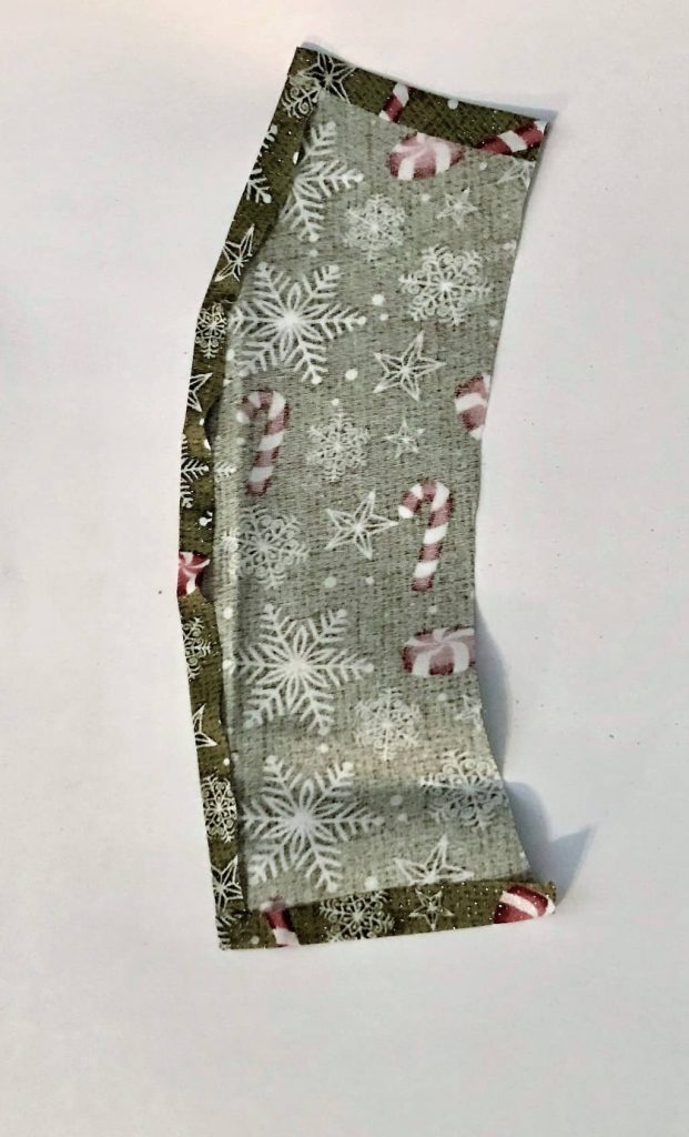 dark green fabric with snowflakes and candy canes on it on a white background