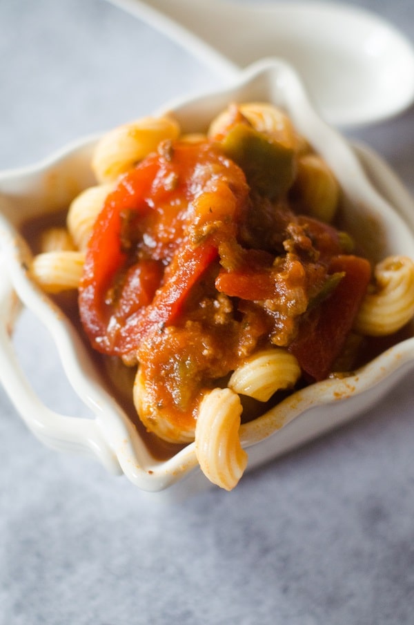 Italian goulash on top of pasta in a white bowl 
