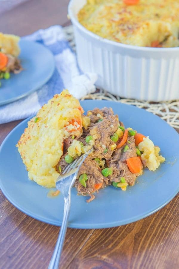 shepherd's pie in a casserole dish and on a blue plate with a fork on it 