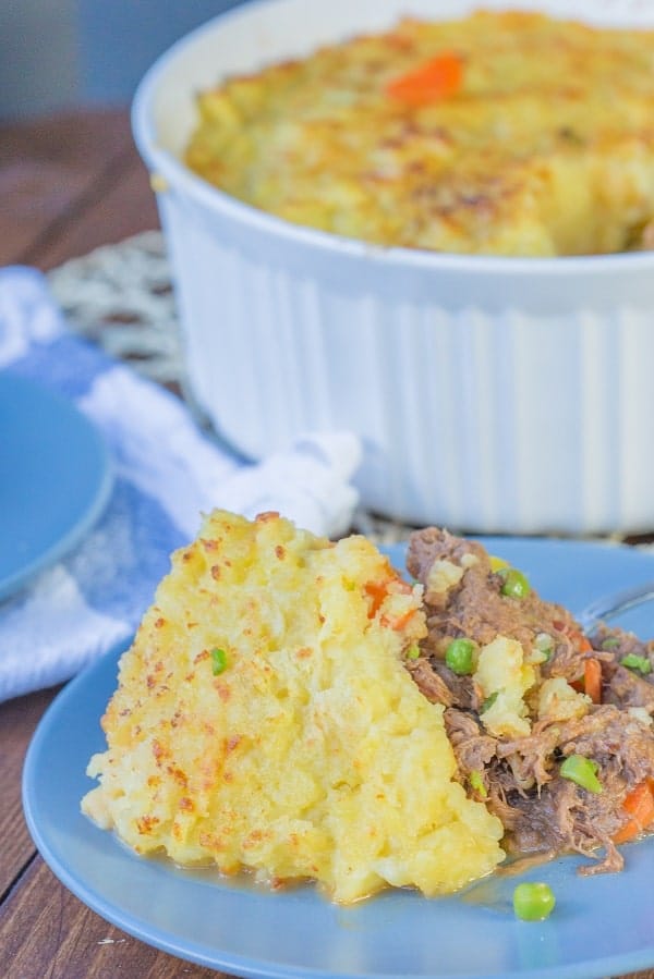 shepherd's pie on a blue plate and in a white baking dish, part of another blue plate is visible next to it
