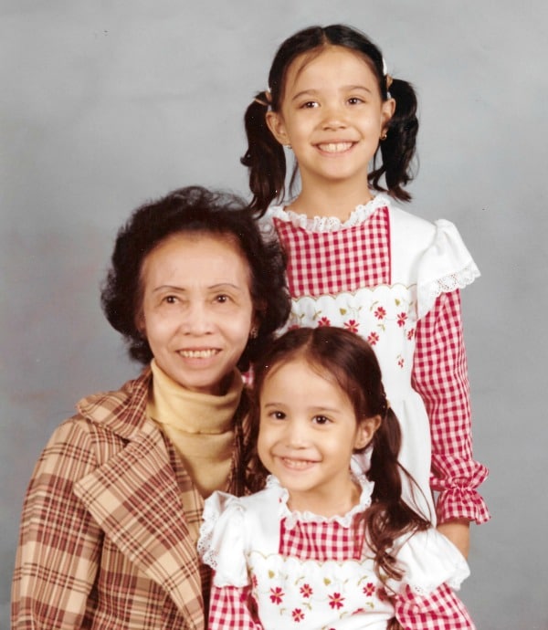 two young girls and their grandma on a gray background