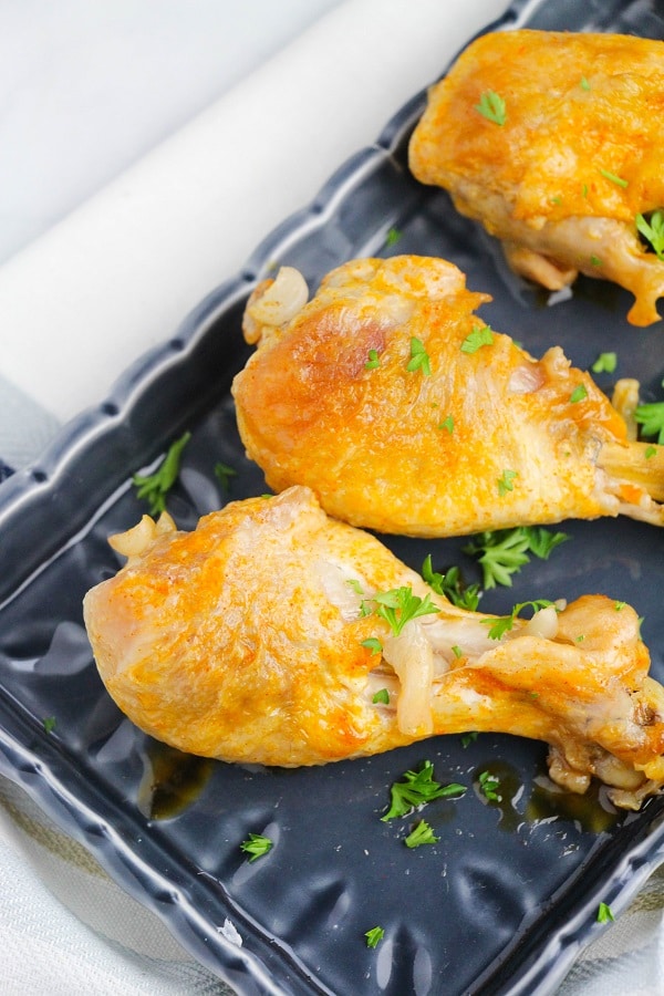 buffalo chicken drumsticks on a black dish on a white table 