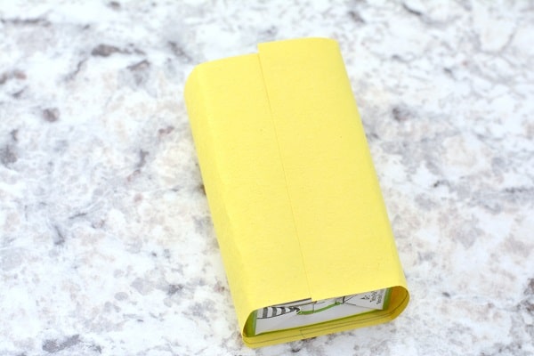 a juice box wrapped in yellow construction paper on a gray kitchen counter