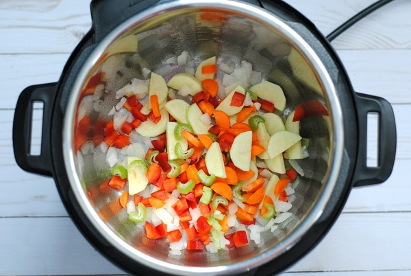 cut up vegetables in an instant pot on a white wood table