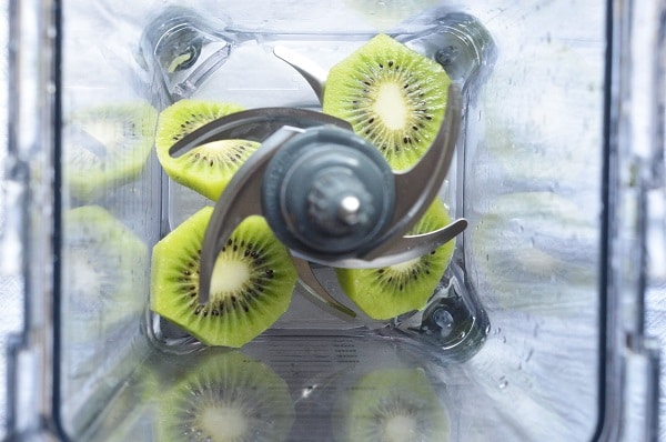 overhead view of sliced kiwi in a blender