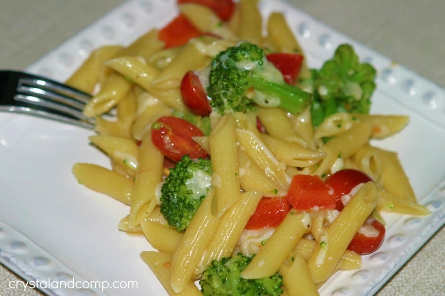 broccoli pasta salad on a white plate with a fork on it