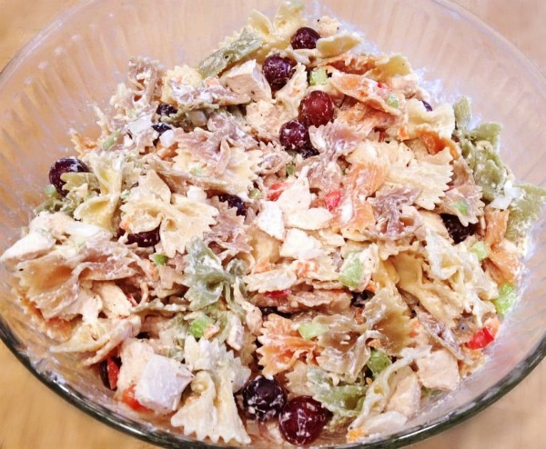 chicken pasta salad in a glass bowl on a wood table