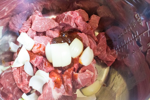 beef, broth, chipotles in adobo sauce, onion, garlic cloves, lime juice, bay leaves, cumin, oregano, salt, pepper and ground cloves in an instant pot
