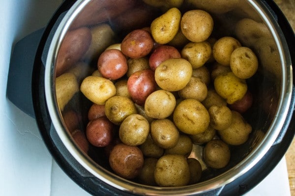 overhead view of potatoes in an instant pot on a white background