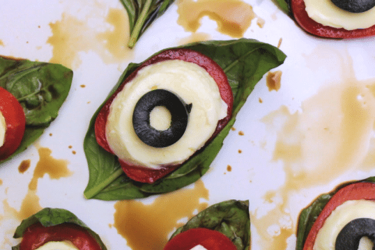 caprese salad ingredients arranged on a white plate to look like eyeballs