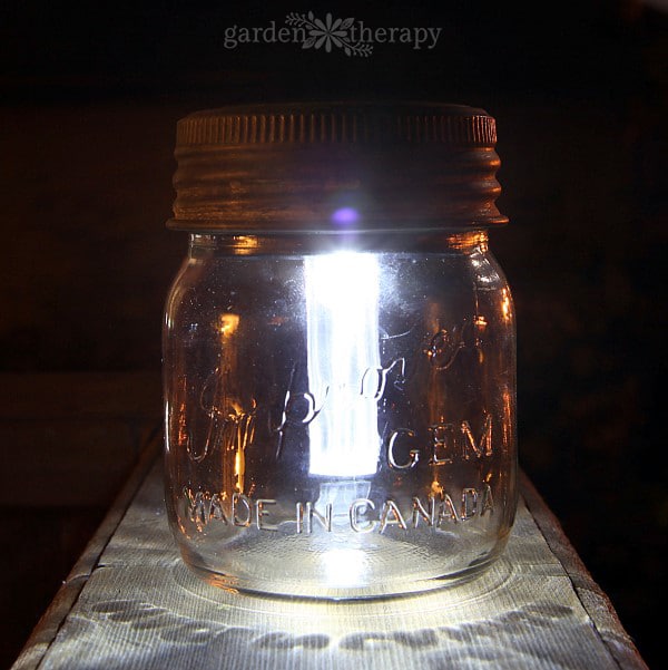 a mason jar with a solar light stake in it