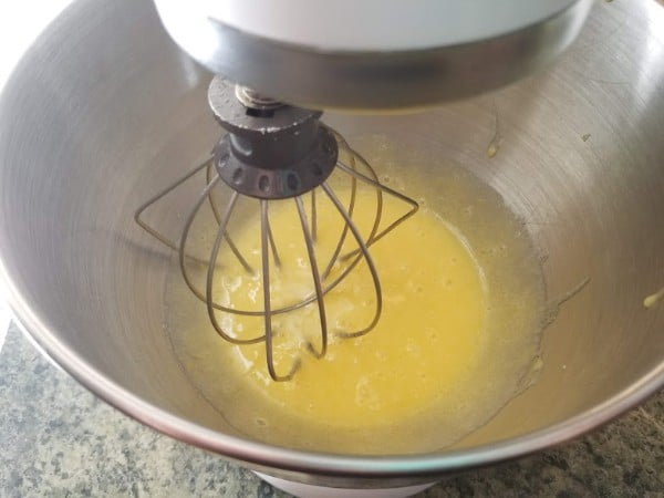 a mixer mixing eggs and sugar in a mixing bowl