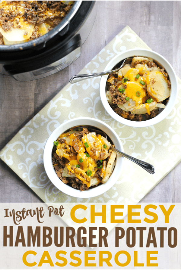 an overhead view of two white bowls of cheesy hamburger potato casserole with a spoon in it on a brown cloth on a brown table with an instant pot in the background with title text reading Instant Pot Cheesy Hamburger Potato Casserole