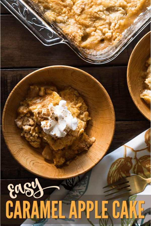 caramel apple dump cake in two bowls on a dark brown table next to a napkin with a fork on it and a glass dish with the rest of the cake in it with title text reading Easy Caramel Apple Cake 