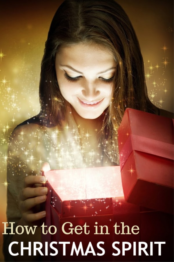 a lady looking in a box with graphics of light coming out of it with title text reading How to Get in the Christmas Spirit