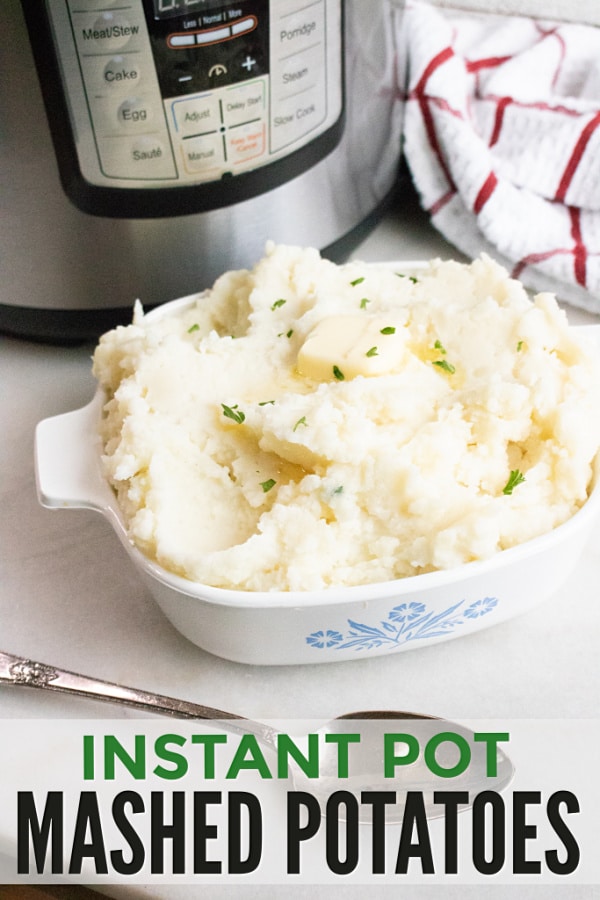 mashed potatoes in a white casserole dish next to a spoon with an instant pot and red and white cloth in the background on a white counter with title text reading Instant Pot Mashed Potatoes
