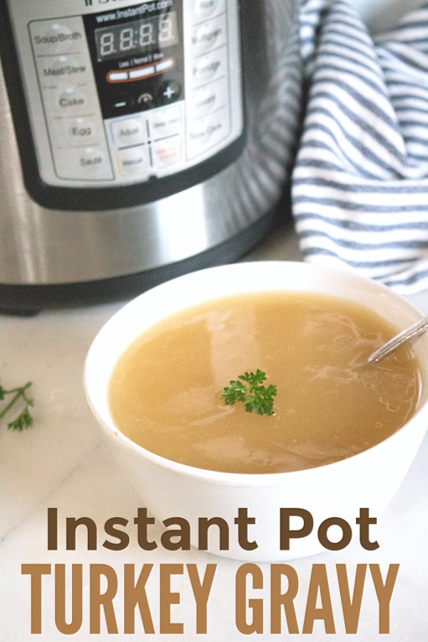 gravy in a white bowl topped with parsley with a spoon in it on a white counter with an instant pot and blue and white linen in the background with title text reading Instant Pot Turkey Gravy