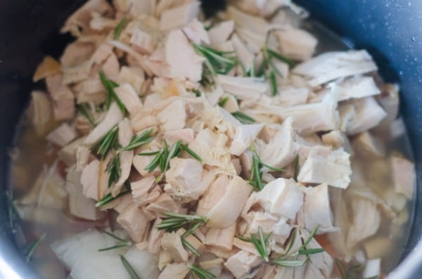 chopped celery, carrots, onion, turkey and chicken broth topped with rosemary in an instant pot