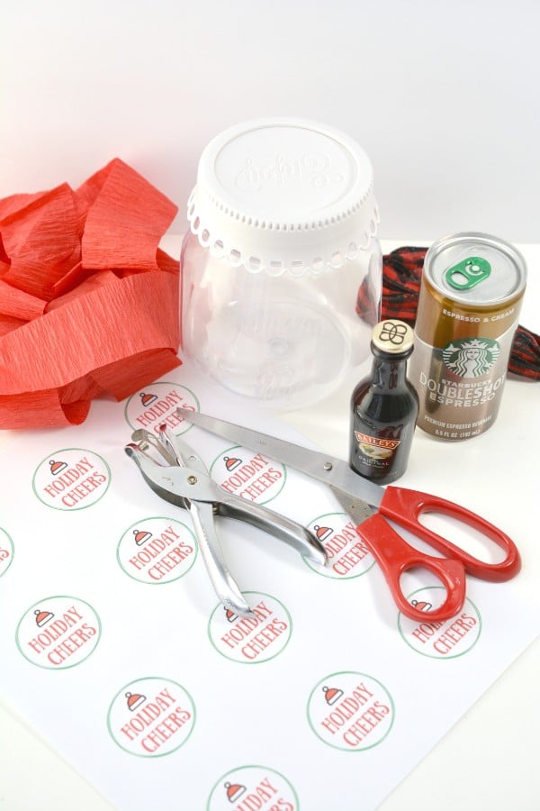 red crepe paper, a glass jar with a white lid, red ribbon, can of Starbucks coffee, bottle of Bailey's liquer, scissors, hole punch, printable with the words Holiday Cheers on it