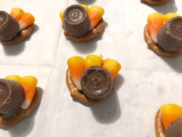 pretzels topped with three candy corn and a Rolo