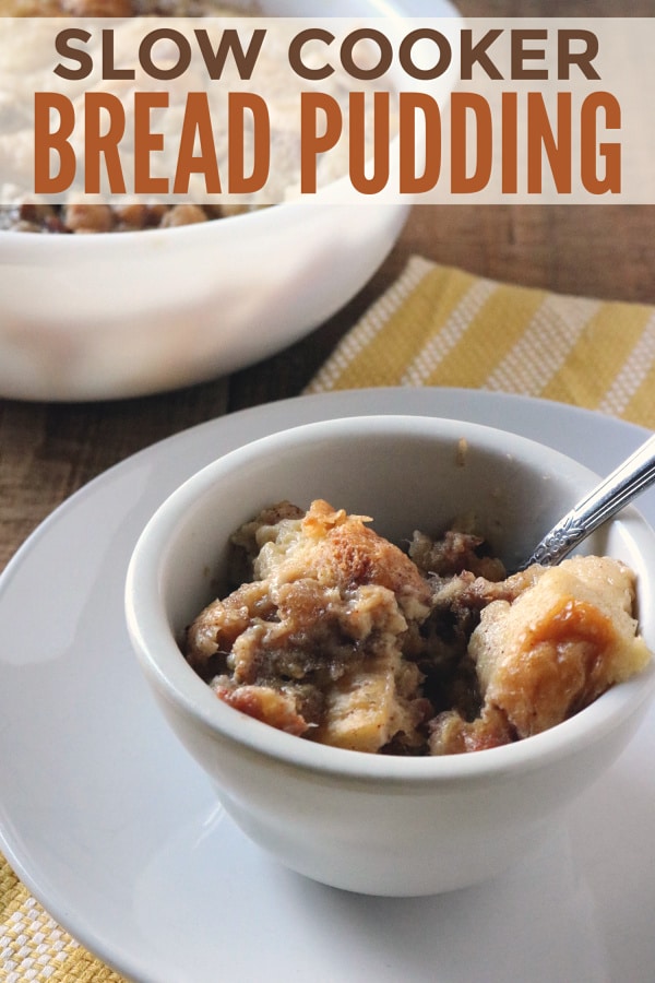 bread pudding in a bowl with a spoon in it on a plate with more bread pudding in another bowl in the background with title text reading Slow Cooker Bread Pudding