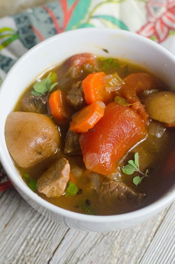 Beef Stew in a white bowl on a linen and table