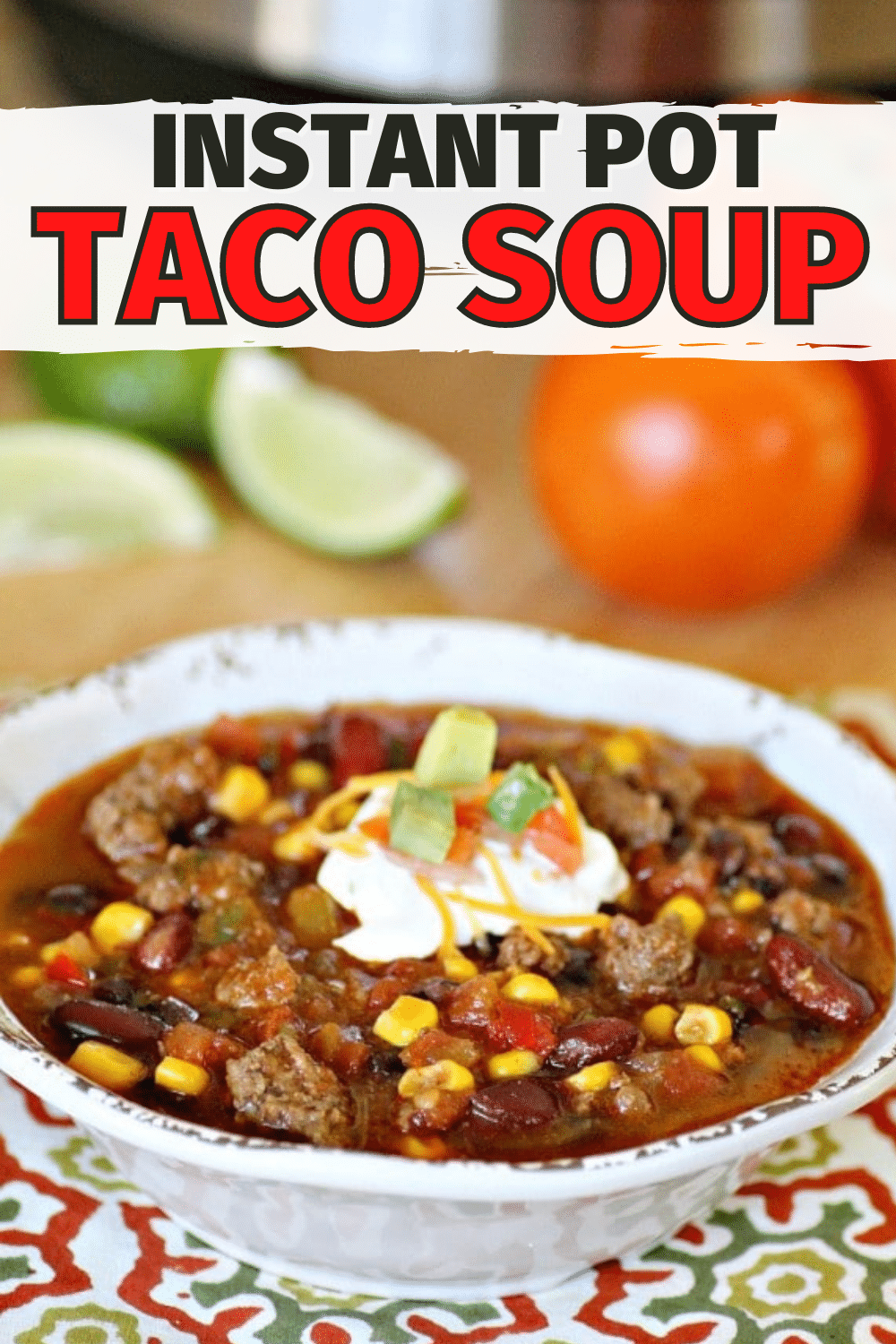 Instant Pot Taco Soup in a white bowl with slices of lime and tomatoes in the background