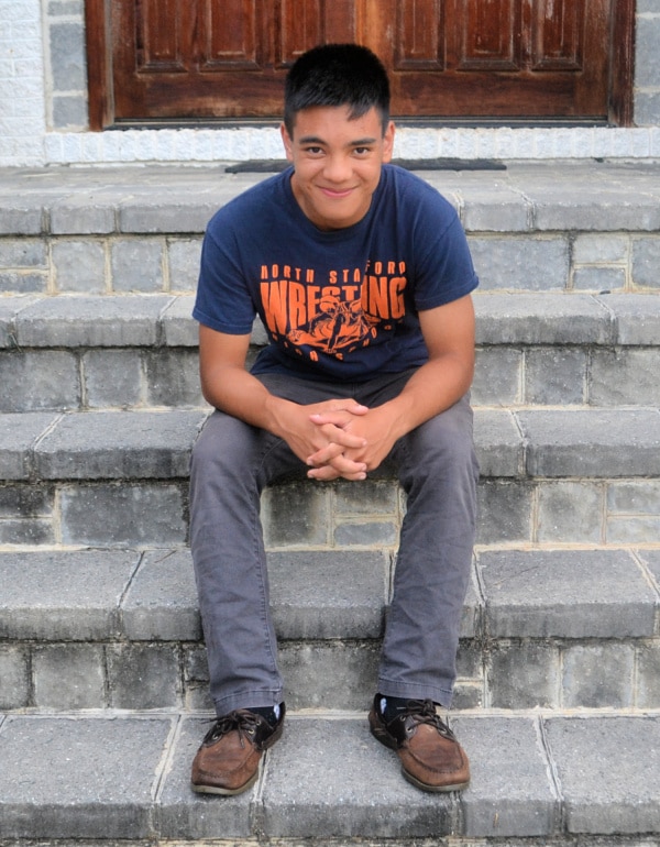 a boy sitting on brick steps with a door in the background