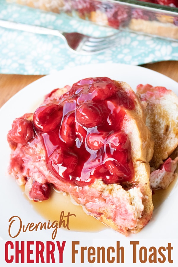 french toast topped with cherries on a white plate with a fork and the rest of the casserole in the background with title text reading Overnight Cherry French Toast 