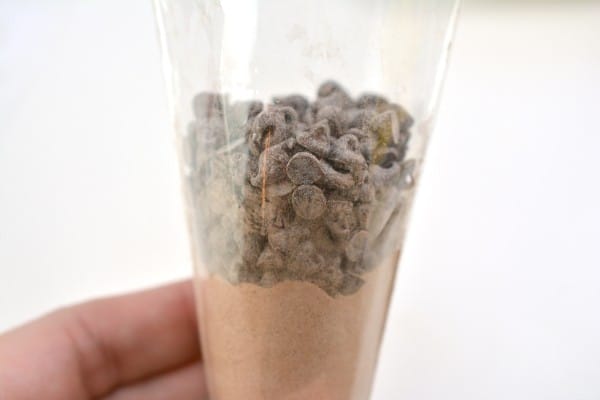 hot cocoa mix topped with mini chocolate chips in a cone shaped plastic bag