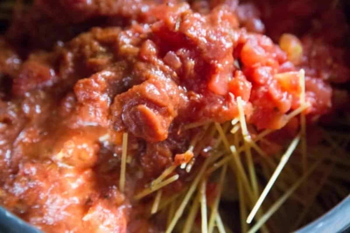 Diced tomatoes and pasta sauce over spaghetti noodles in an instant pot.
