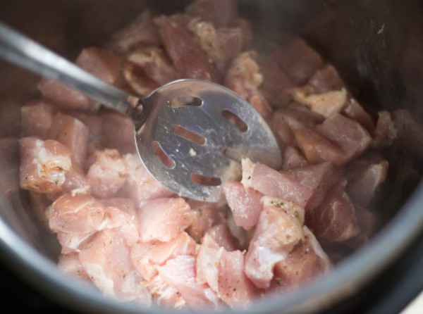 diced pork in an instant pot with a spoon in it