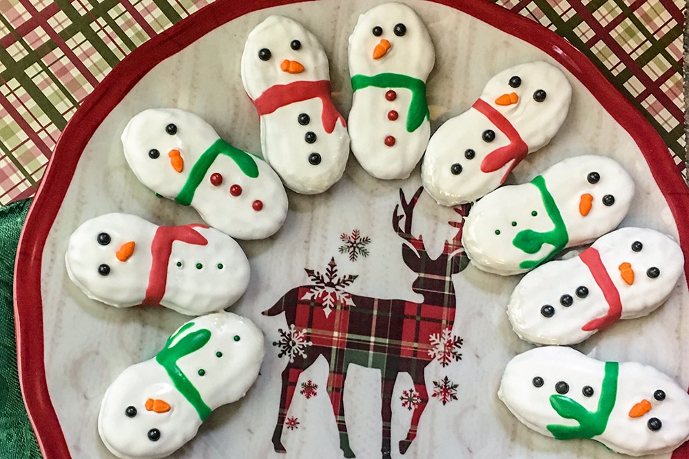 nutter butter cookies decorated to look like a snowman on a reindeer plate 
