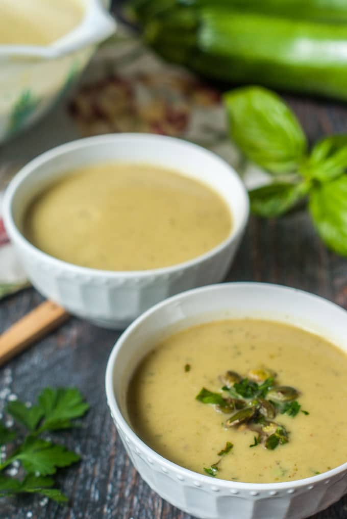 thai curry zucchini soup in two white bowls